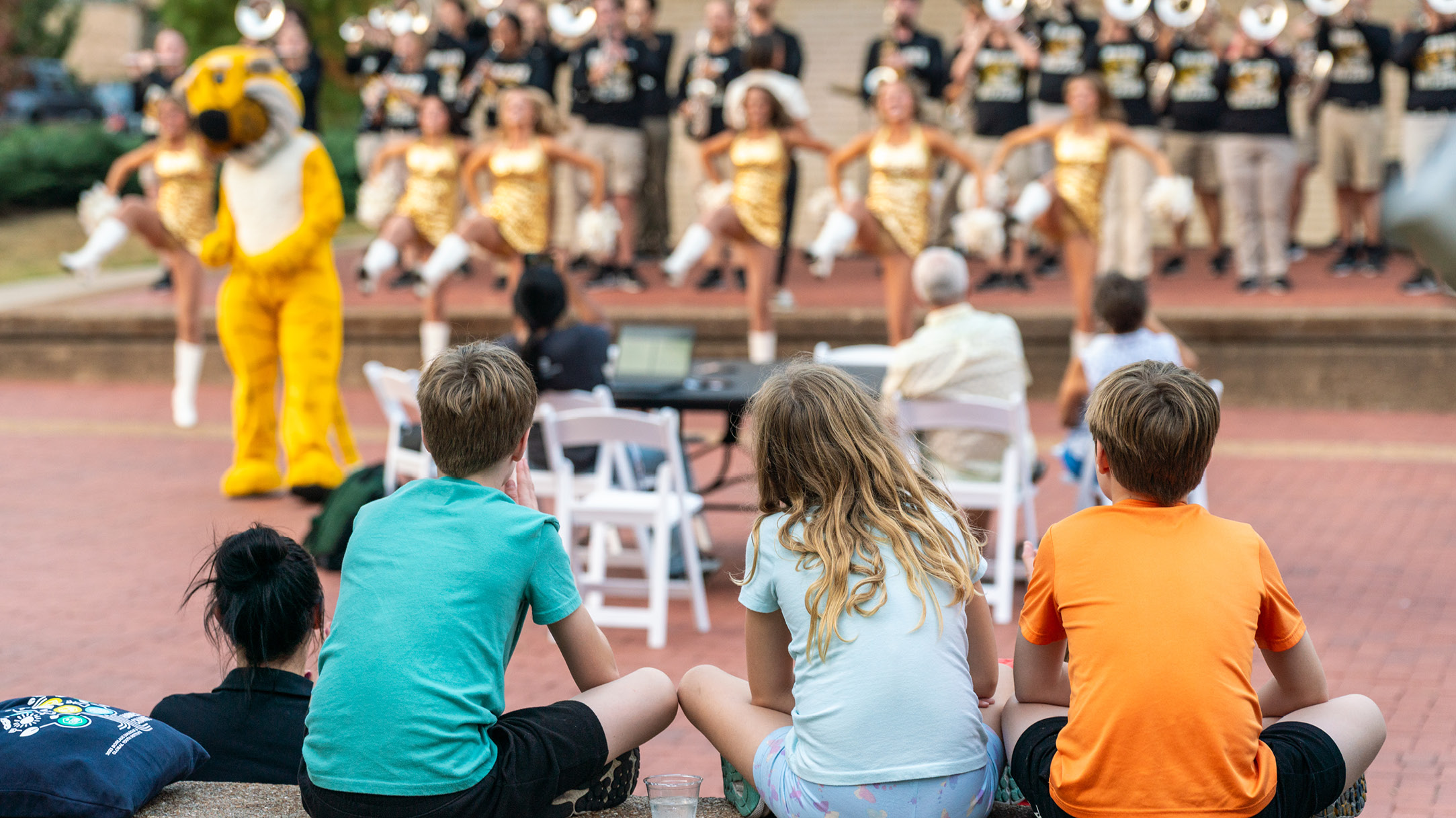 kids watching mini mizzou perform on Lowry Mall