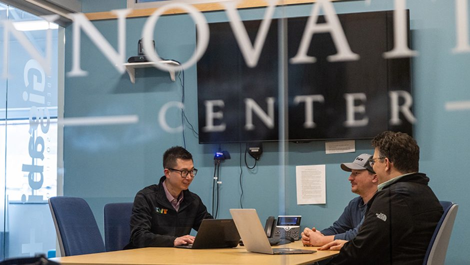 A photo of two people in a building talking about business plans