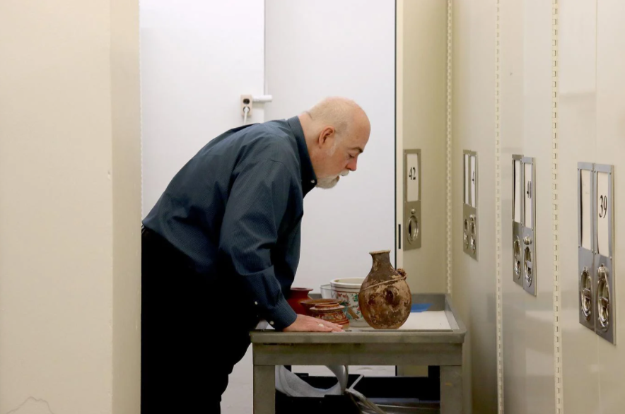 Bruce Cox, interim museum director, puts away ancient containers at Ellis Library in Columbia. 