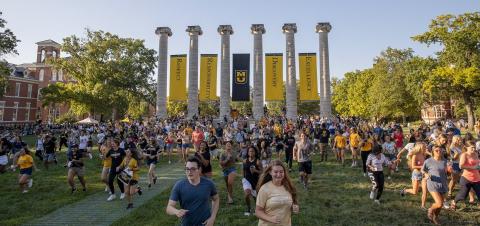 students running through the columns