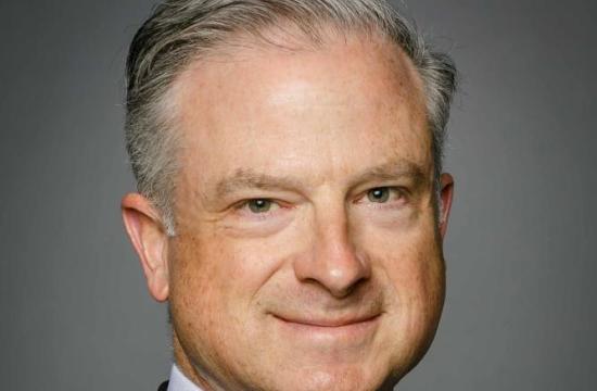 Photo of Interim Dean Drury wearing a black suit jacket and tie.
